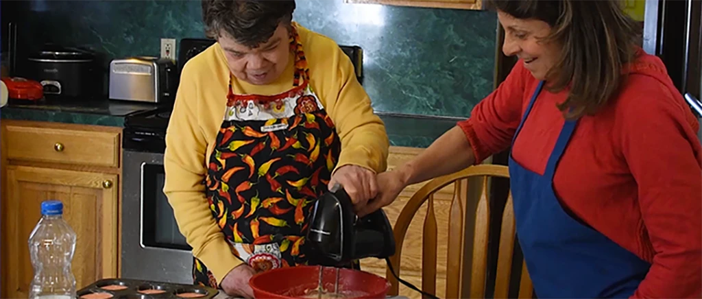 Two women in kitchen mixing cake batter