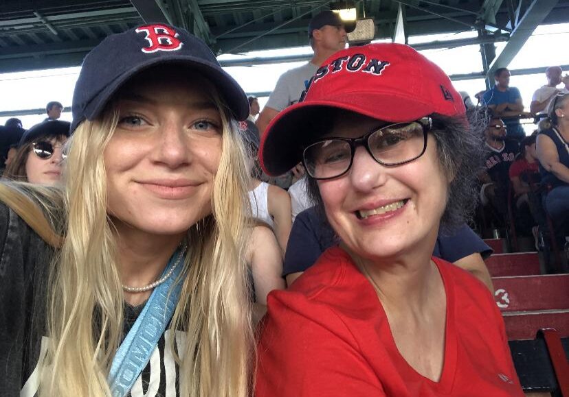 Services For Adults Link - Photo shows two young women in baseball caps at Red Sox game